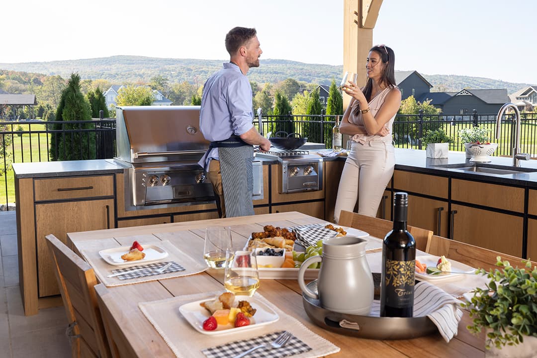 man and woman talking beside bbq grill